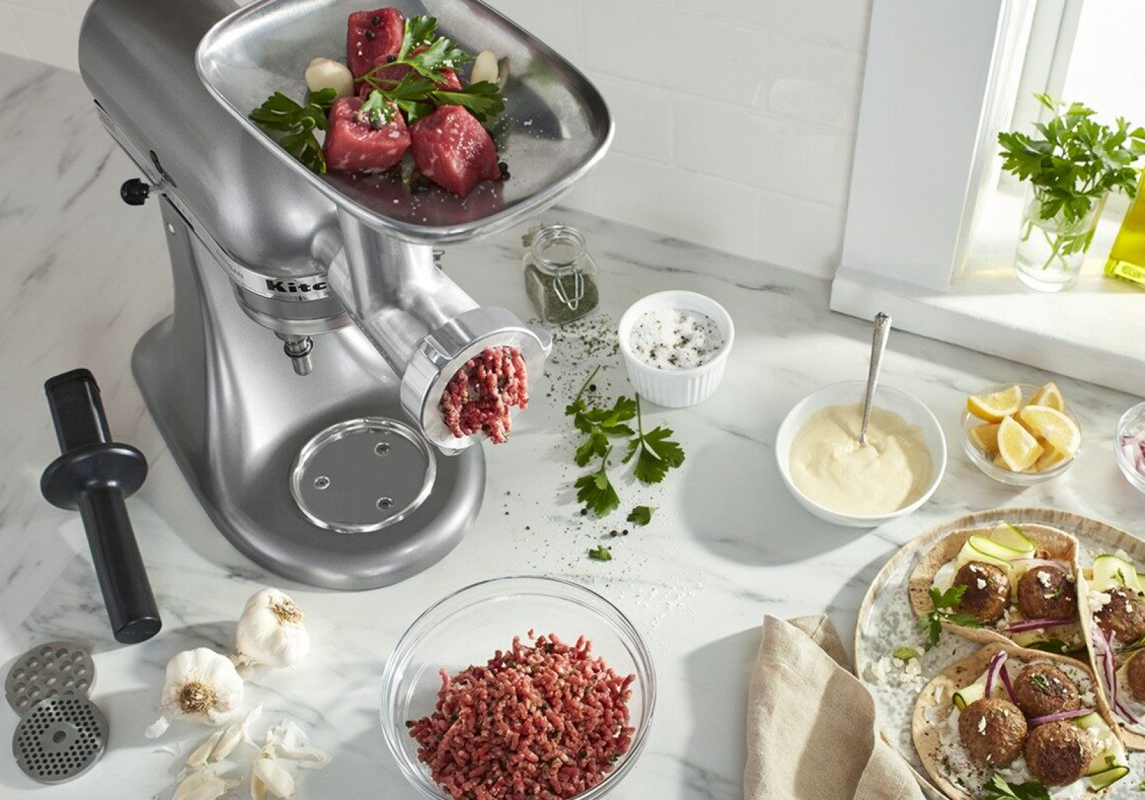 Silver stand mixer with a meat grinder attachment grinding beef Silver stand mixer with a meat grinder attachment grinding beef