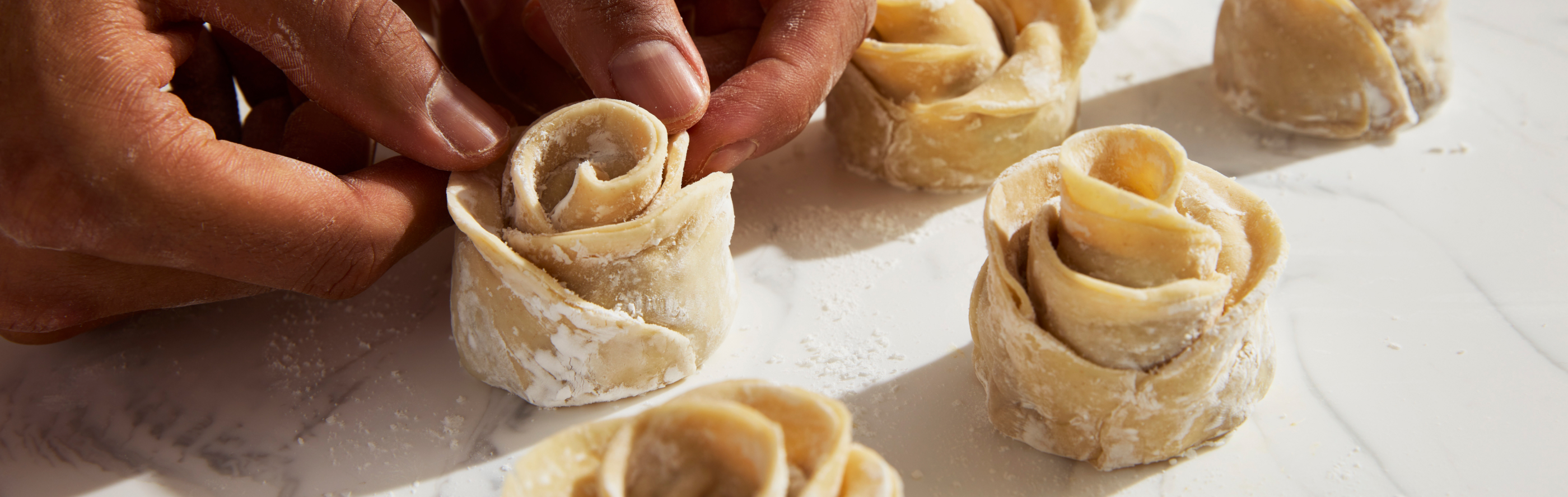 Person creating small flowers with dough