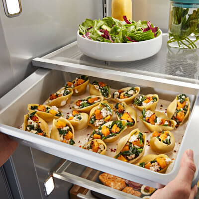 A refrigerator tray filled with a sheet of fresh food
