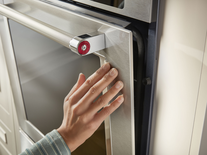 Person closing a KitchenAid® wall oven