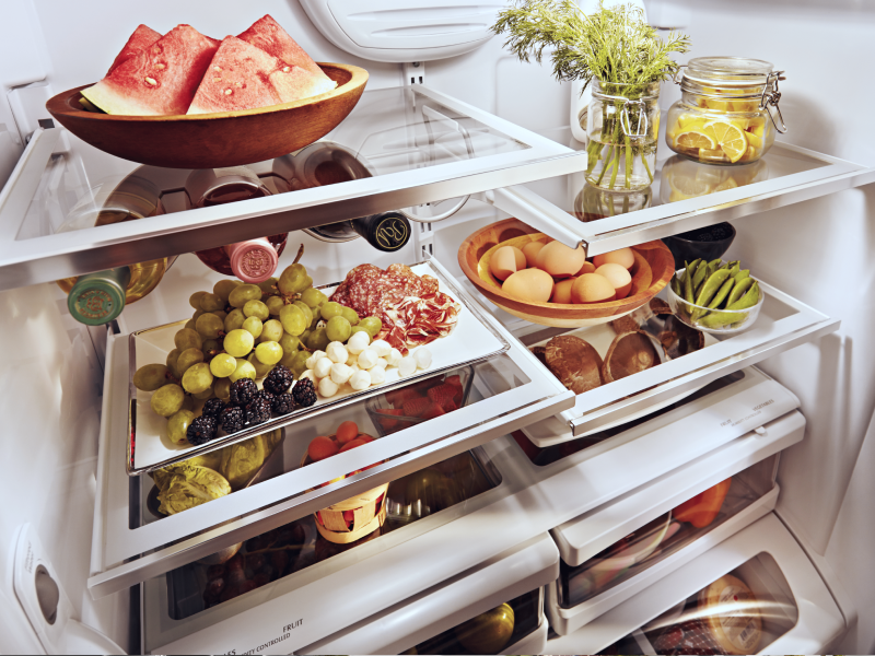 A stocked refrigerator with fresh fruit and ingredients.