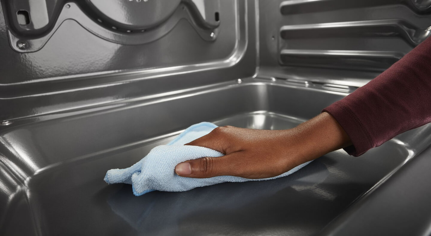 Person cleaning the inside of an oven