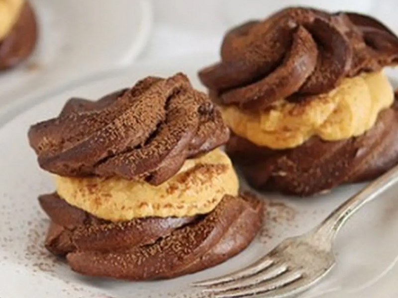 Pumpkin chocolate cream puffs next to fork