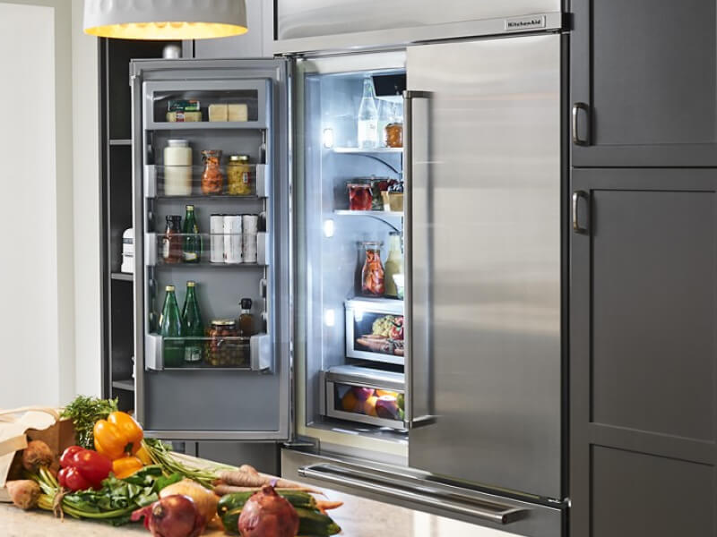 Open KitchenAid® French door refrigerator behind island with fresh produce Open KitchenAid® French door refrigerator behind island with fresh produce