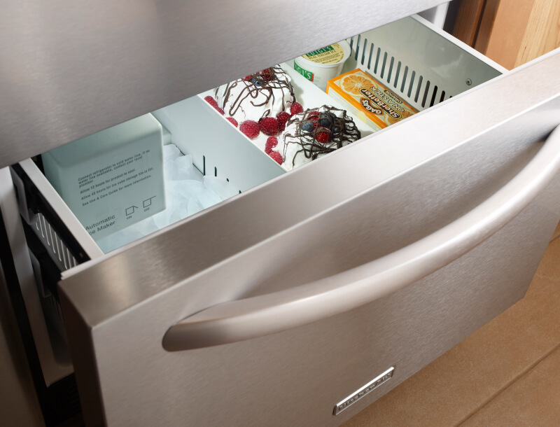 Freezer drawer slightly ajar with ice cream and sorbet inside Freezer drawer slightly ajar with ice cream and sorbet inside