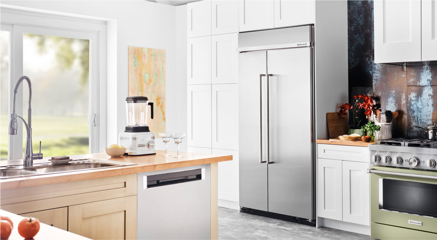 A built-in KitchenAid® refrigerator surrounded by white cabinetry A built-in KitchenAid® refrigerator surrounded by white cabinetry
