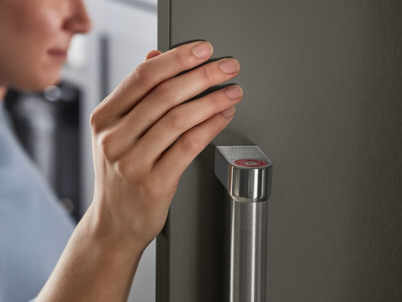 Person touching a stainless steel refrigerator door