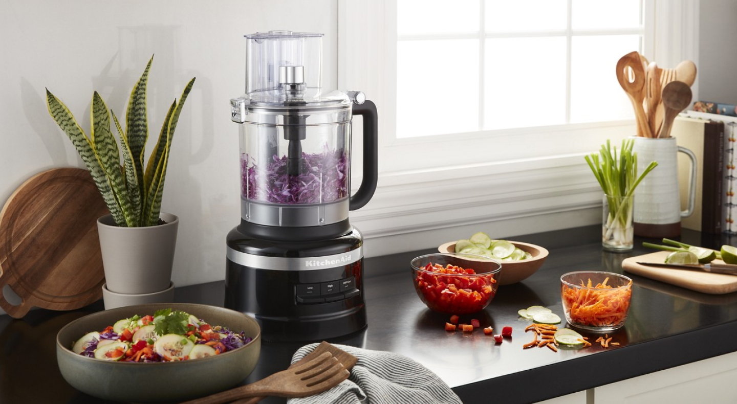 KitchenAid® food processor on a countertop with fresh produce