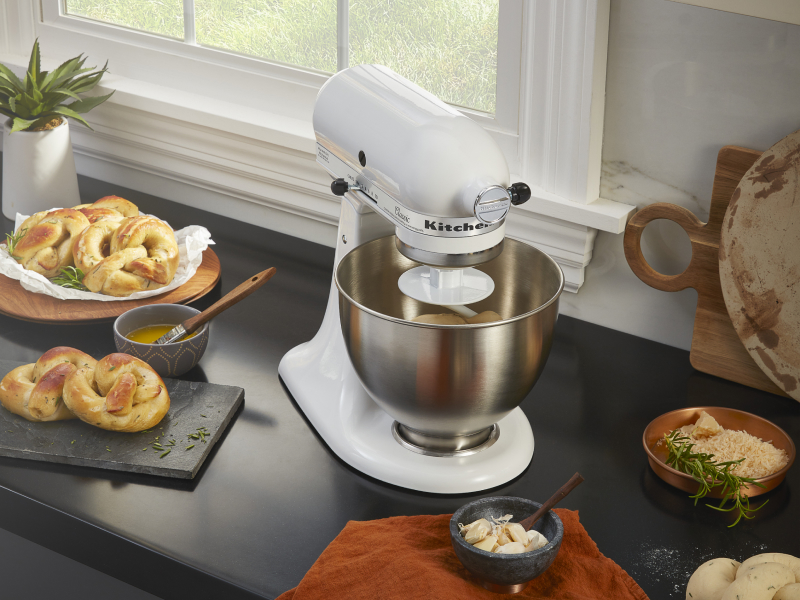 A stand mixer next to freshly baked pretzels