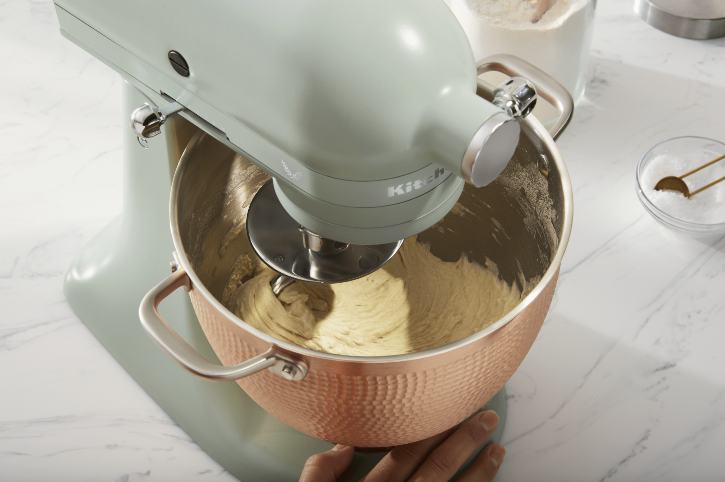 Person making pretzel dough in rose gold, textured stand mixer bowl Person making pretzel dough in rose gold, textured stand mixer bowl