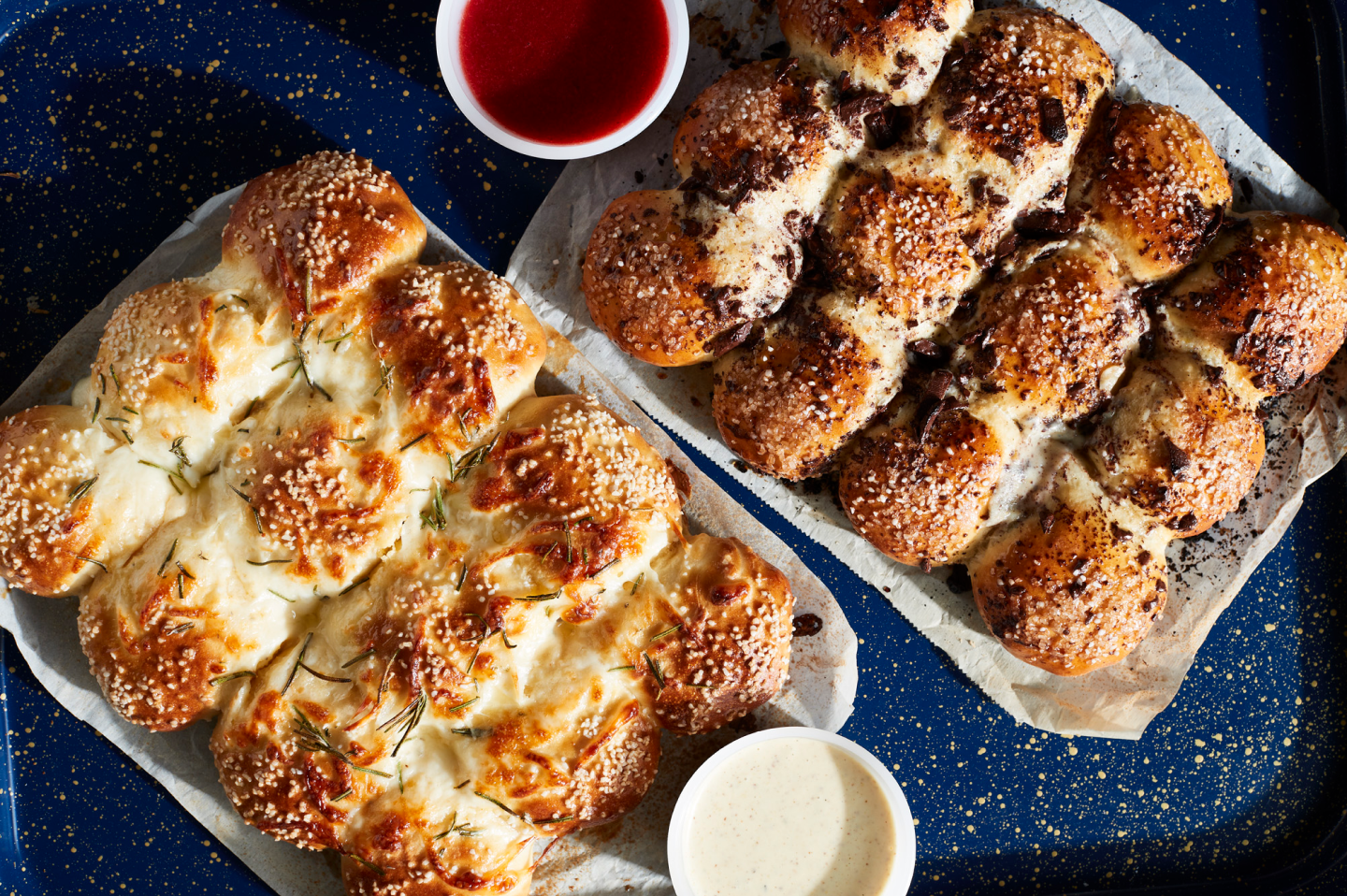 Savory pretzel rolls on parchment paper next to various dips Savory pretzel rolls on parchment paper next to various dips