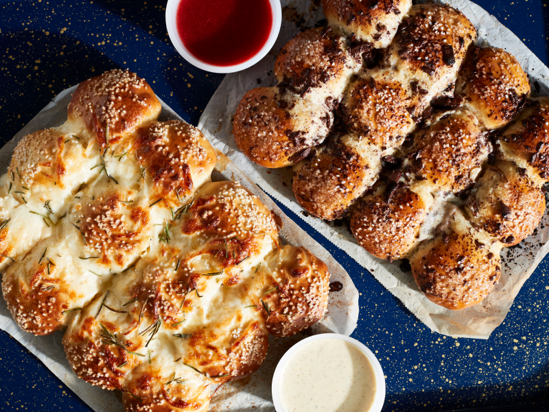 Savory pretzel rolls on parchment paper next to various dips Savory pretzel rolls on parchment paper next to various dips
