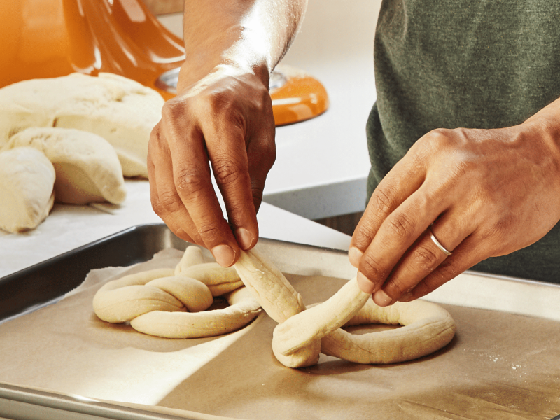 Person twisting dough into a pretzel shape