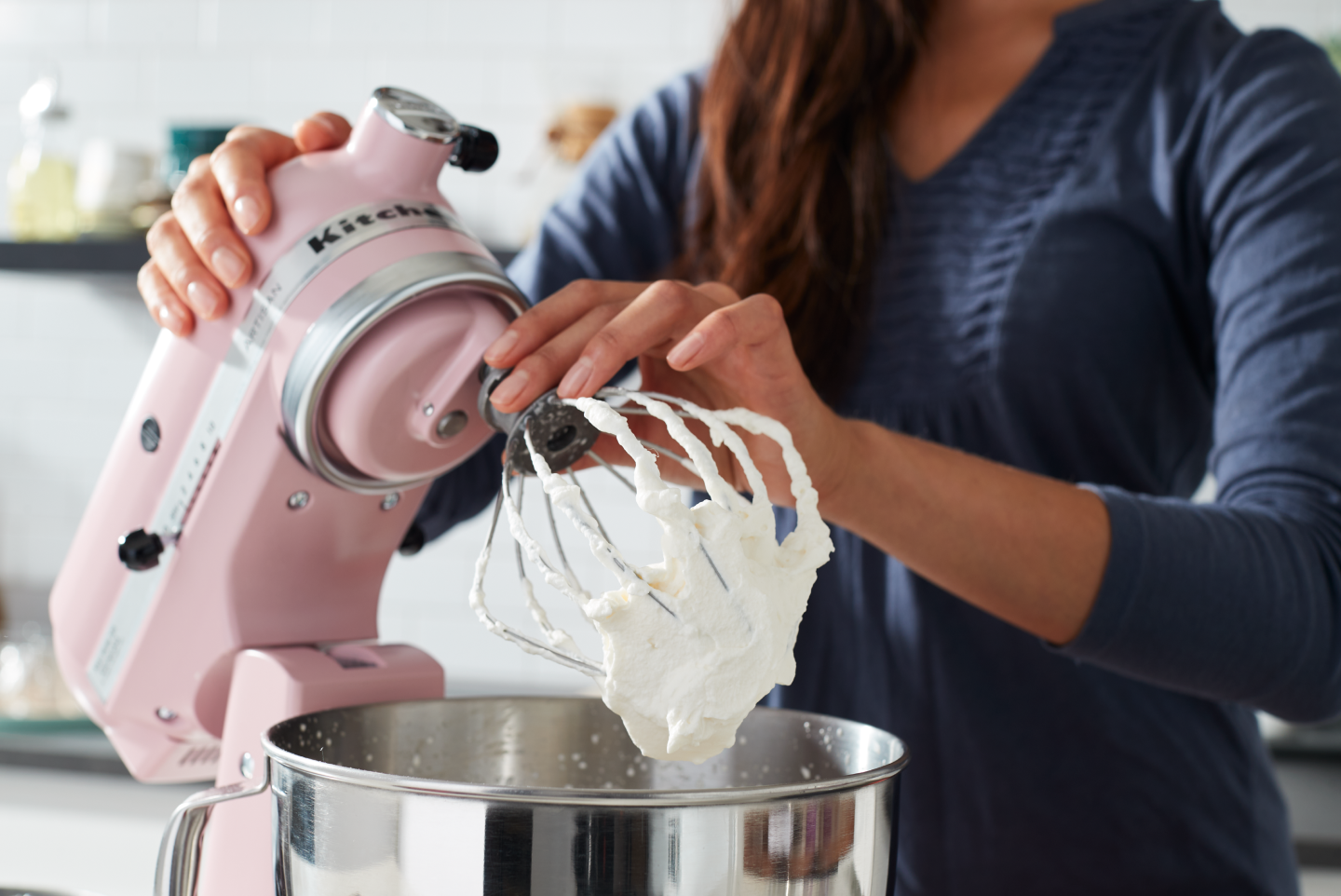 A woman using a pink KitchenAid® stand mixer to make homemade whipped cream A woman using a pink KitchenAid® stand mixer to make homemade whipped cream