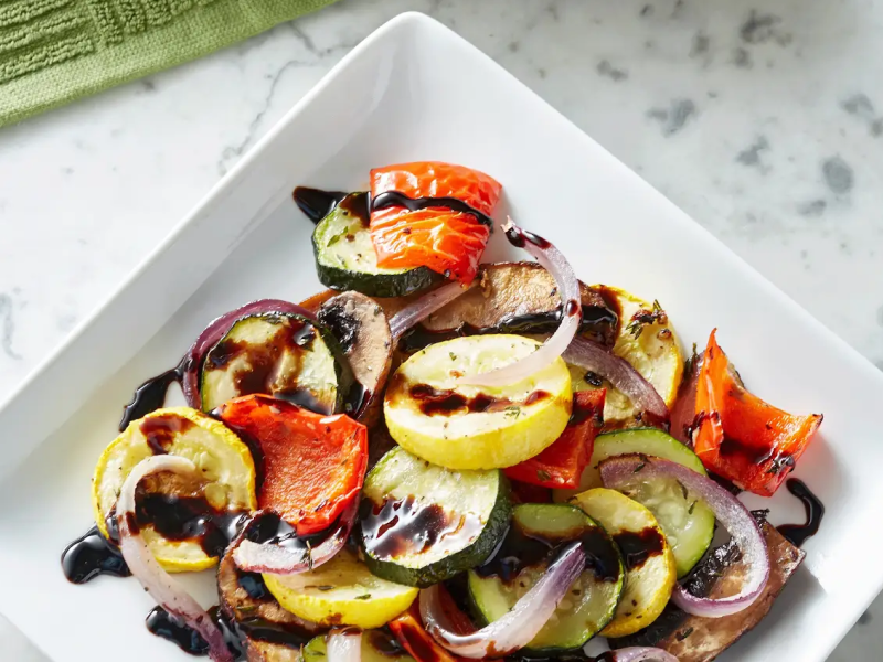 Assorted roasted vegetables drizzled in sauce