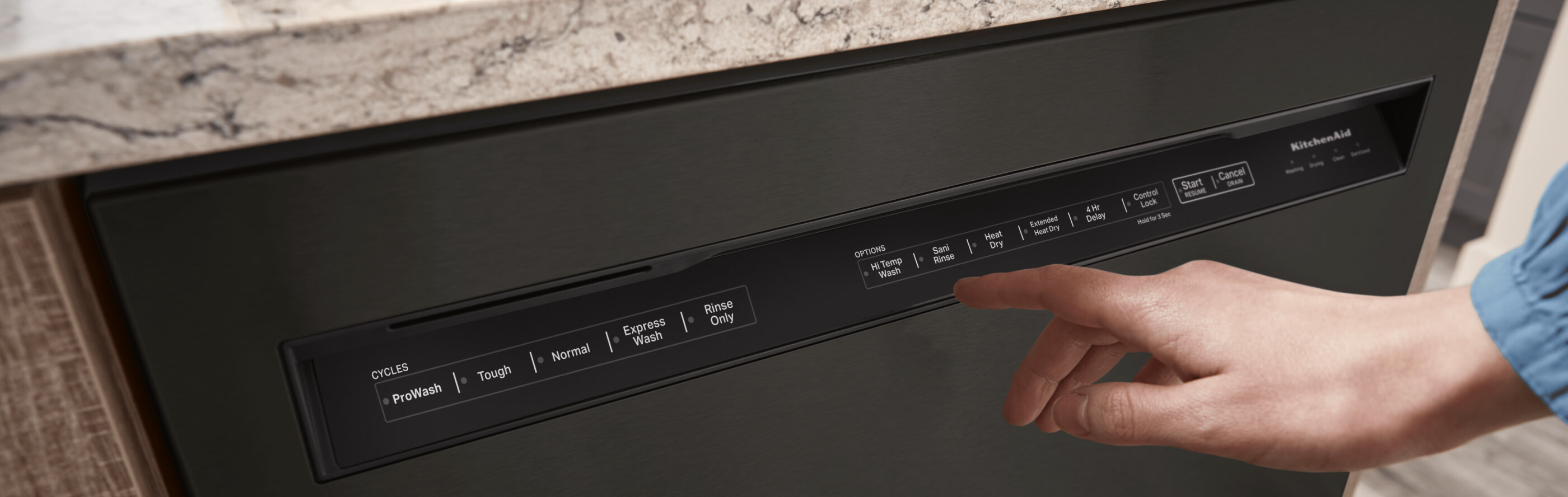 Hand touching a KitchenAid® front control dishwasher