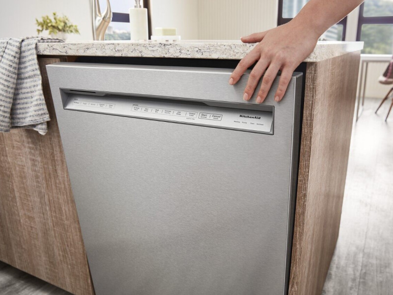 Hand touching a KitchenAid® front control dishwasher Hand touching a KitchenAid® front control dishwasher