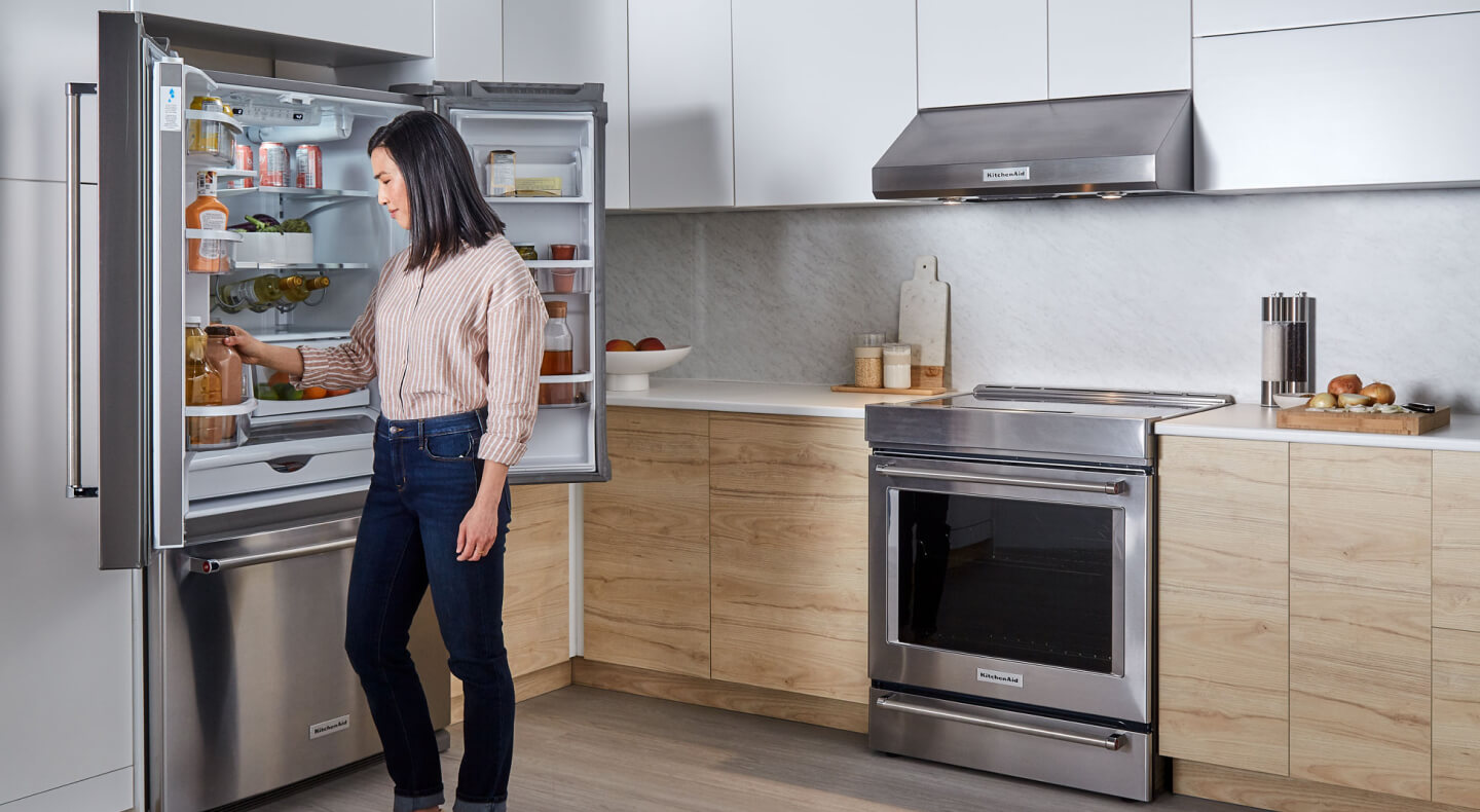 Person looking in KitchenAid® french door refrigerator Person looking in KitchenAid® french door refrigerator