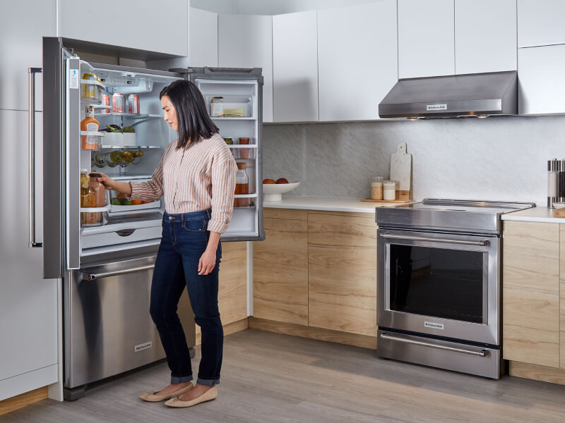 Person looking in KitchenAid® french door refrigerator Person looking in KitchenAid® french door refrigerator