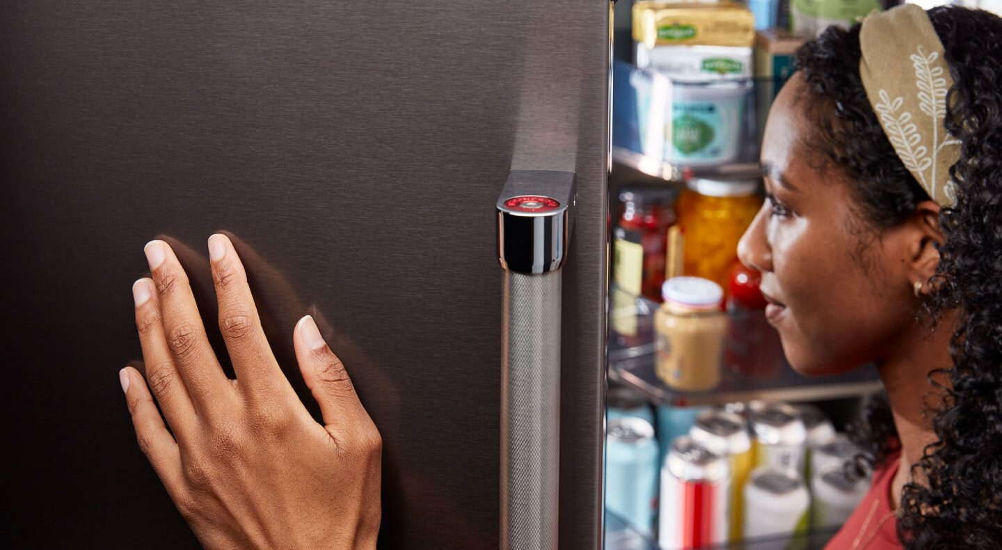 Person holding door open on KitchenAid® refrigerator Person holding door open on KitchenAid® refrigerator