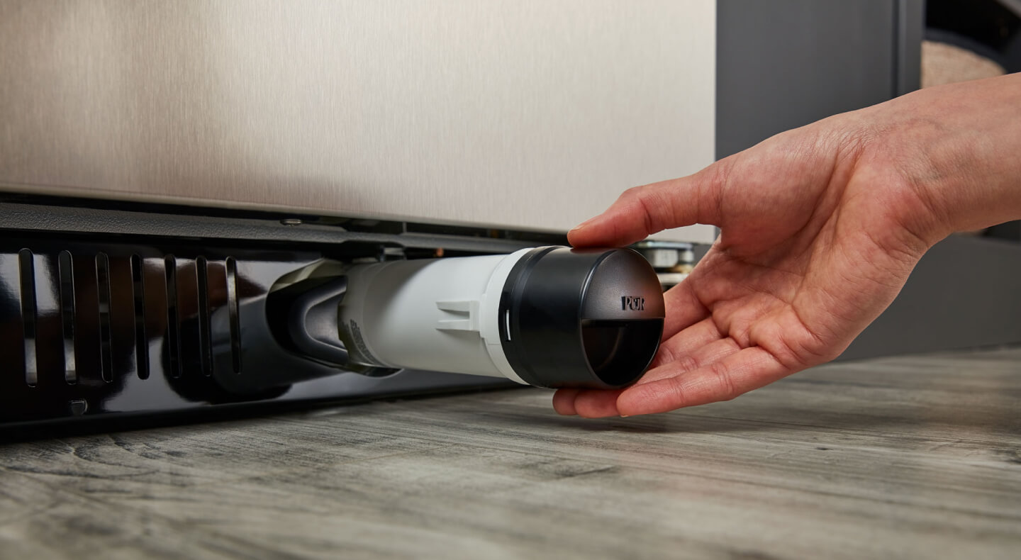 Person removing refrigerator water filter Person removing refrigerator water filter