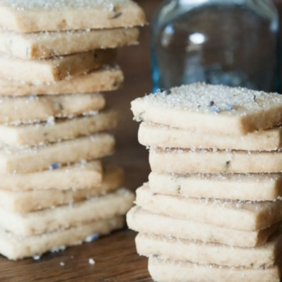 Stacks of lavender shortbread cookies on a countertop