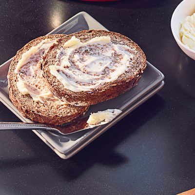 Light, whipped butter spread on slices of bread next to butter knife