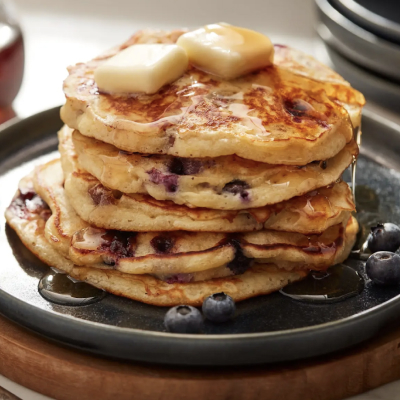 Plate of blueberry pancakes topped with syrup and butter