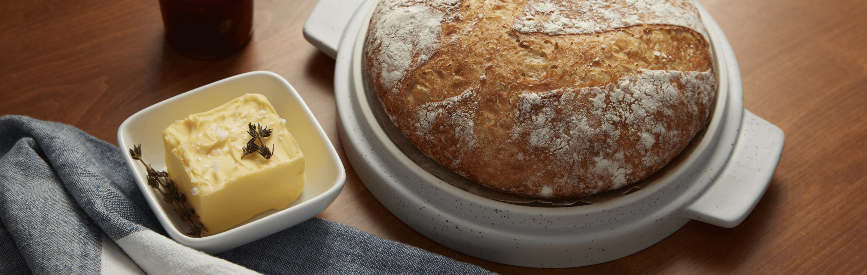 Loaf of sourdough bread next to dish of butter