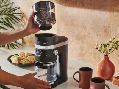Coffee beans being placed on the base of burr coffee grinder. Coffee beans being placed on the base of burr coffee grinder.