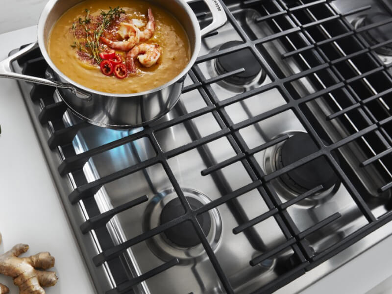 An overhead view of a KitchenAid® gas cooktop simmering a pot of food An overhead view of a KitchenAid® gas cooktop simmering a pot of food