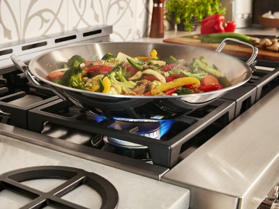 Large pan with vegetables cooking on power burner