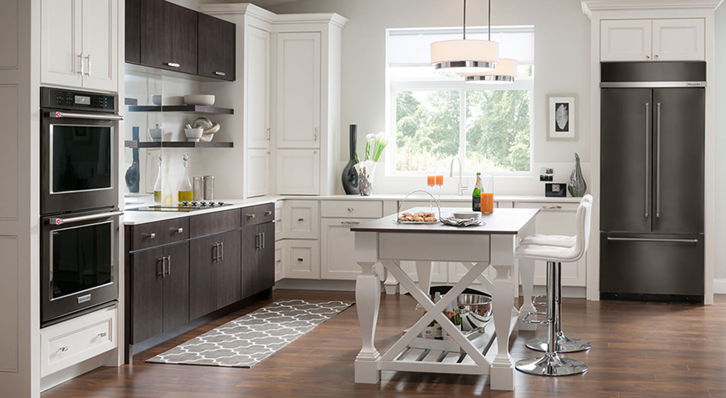 A bright, L-shaped kitchen layout with white cabinets and stainless steel appliances