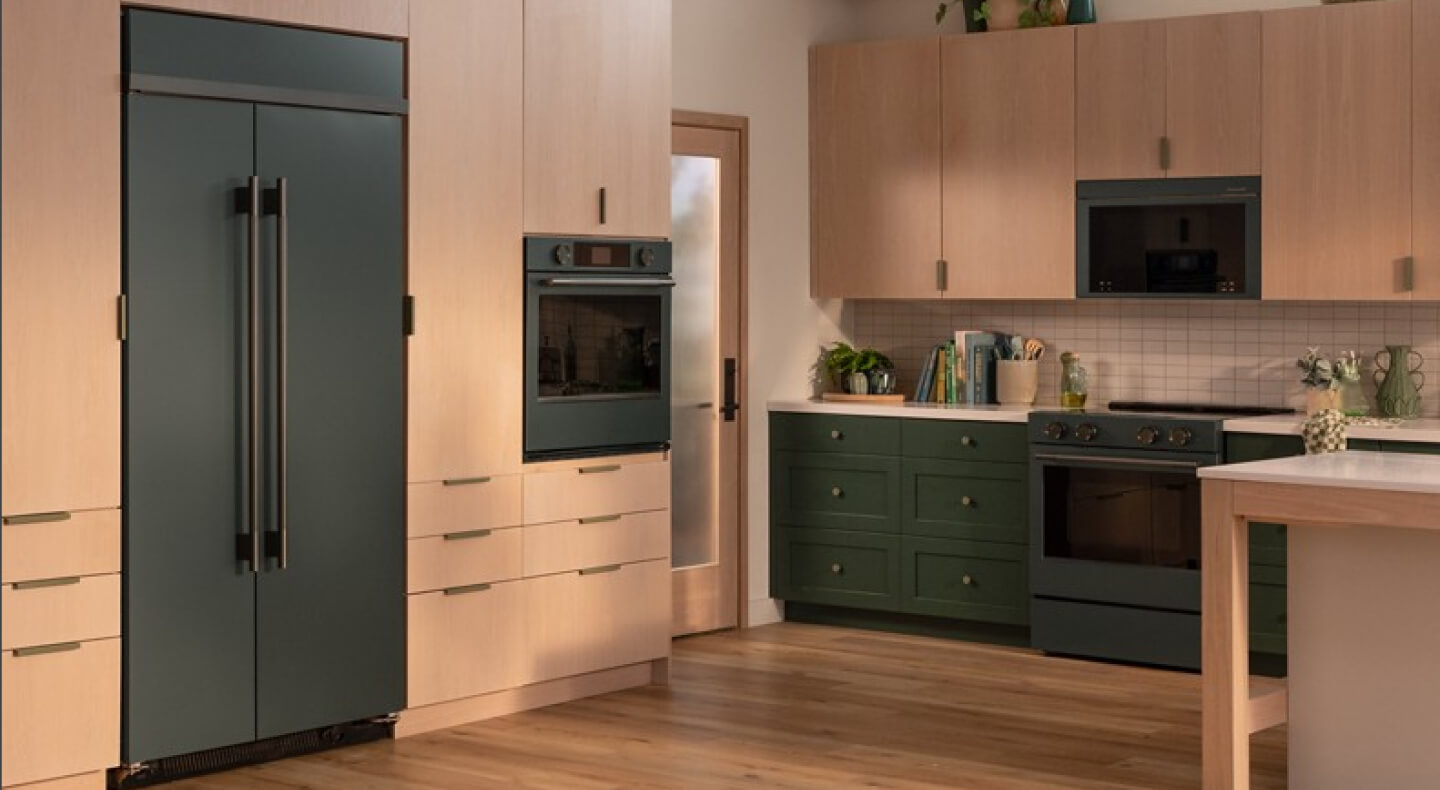 A kitchen with wooden cabinetry and a built-in refrigerator in Juniper green