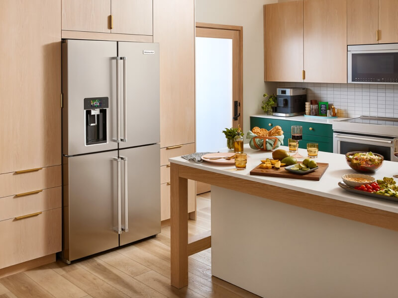 A 4-door refrigerator in a kitchen with wooden cabinetry and a kitchen island