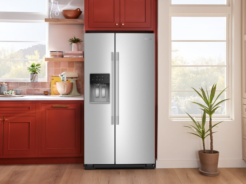  A stainless steel French door refrigerator surrounded by red cabinetry