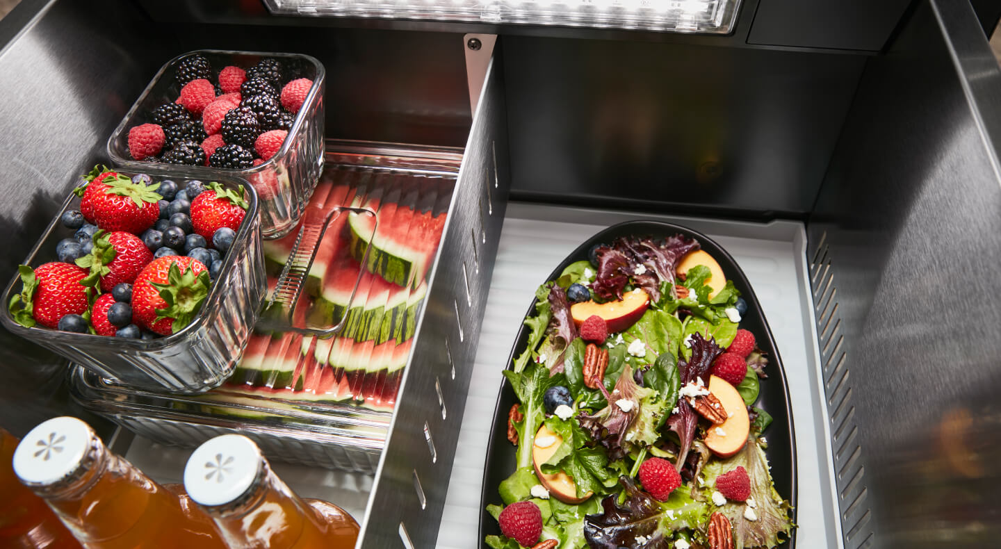Fresh fruit and a salad stored inside a refrigerator Fresh fruit and a salad stored inside a refrigerator