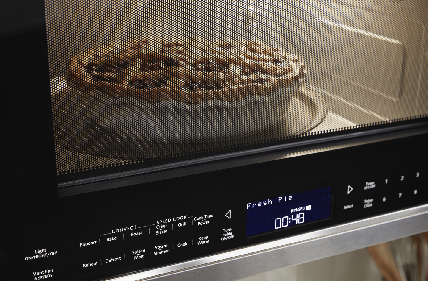 A closeup of a KitchenAid® microwave baking a pie. A closeup of a KitchenAid® microwave baking a pie.