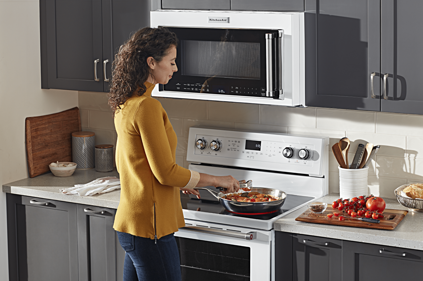 Person adding ingredients to a skillet on an electric stovetop  Person adding ingredients to a skillet on an electric stovetop
