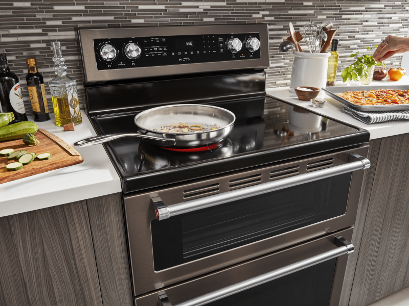 Large skillet cooking food on the electric stovetop of a KitchenAid® double oven range Large skillet cooking food on the electric stovetop of a KitchenAid® double oven range