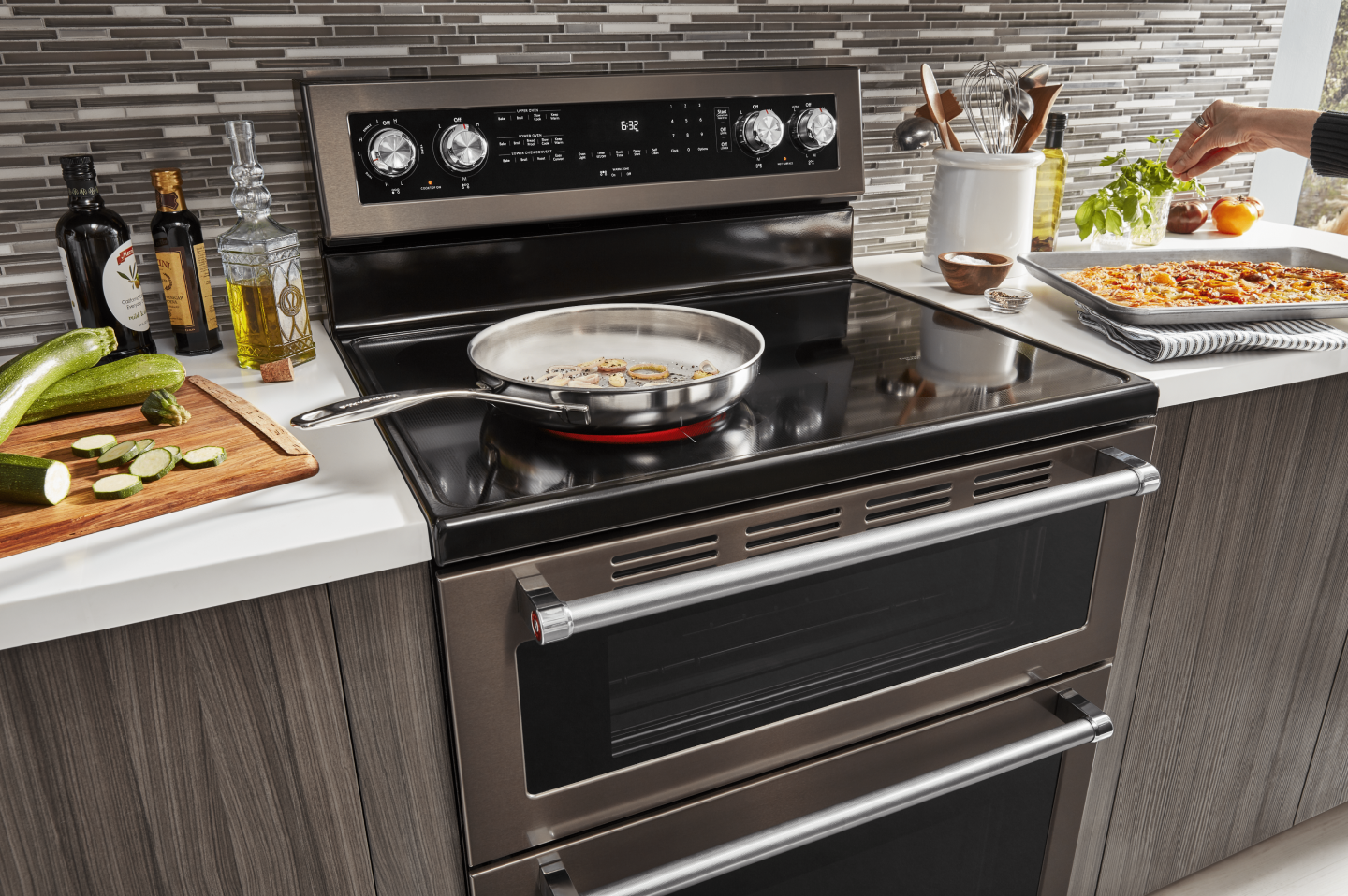 Large skillet cooking food on the electric stovetop of a KitchenAid® double oven range Large skillet cooking food on the electric stovetop of a KitchenAid® double oven range