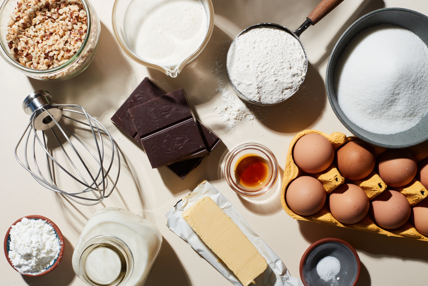 Top view of whisk attachment and pie ingredients including flour, sugar, eggs, butter, milk, chocolate and walnuts Top view of whisk attachment and pie ingredients including flour, sugar, eggs, butter, milk, chocolate and walnuts