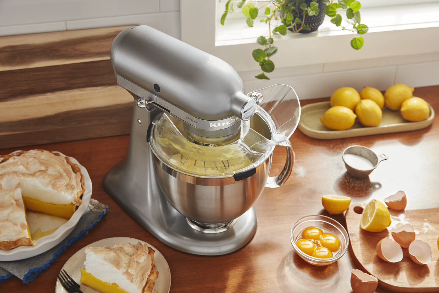 Silver KitchenAid® stand mixer with Pour Shield on countertop with lemon meringue pie and ingredients Silver KitchenAid® stand mixer with Pour Shield on countertop with lemon meringue pie and ingredients
