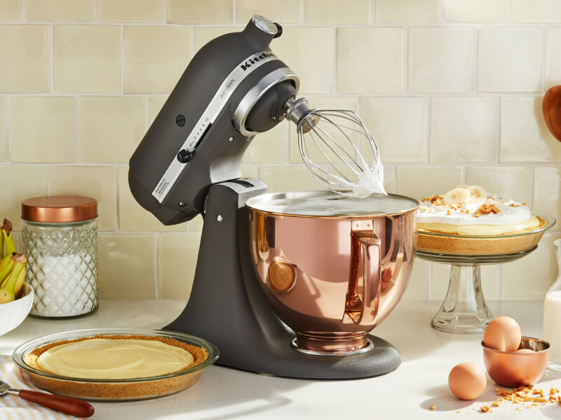 A KitchenAid® stand mixer with a wire whisk/whip accessory with fresh whipped egg whites on the counter of a modern kitchen. A KitchenAid® stand mixer with a wire whisk/whip accessory with fresh whipped egg whites on the counter of a modern kitchen.