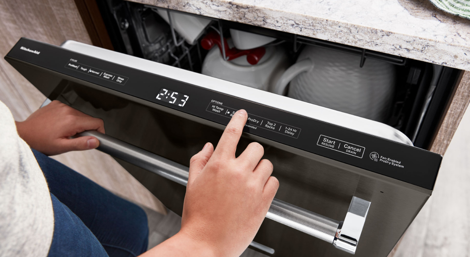 Person using the top control panel of a built-in dishwasher Person using the top control panel of a built-in dishwasher