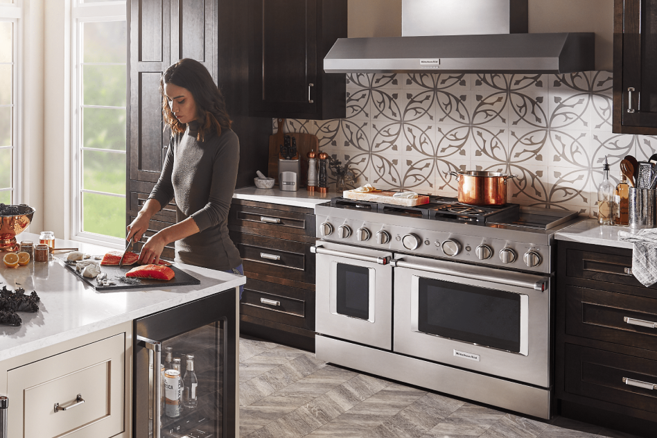 Woman prepping food in front of a double-oven commercial-style range Woman prepping food in front of a double-oven commercial-style range