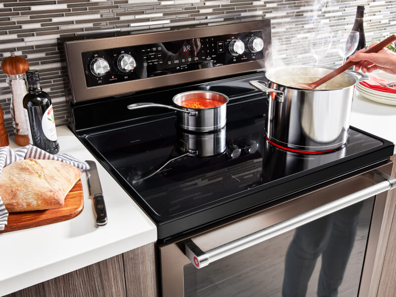 A pot and a sauce pan heating on an electric range