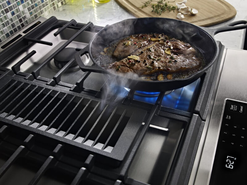 Steak cooking on a gas cooktop
