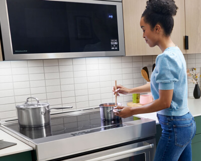 Person stirring at a cooktop