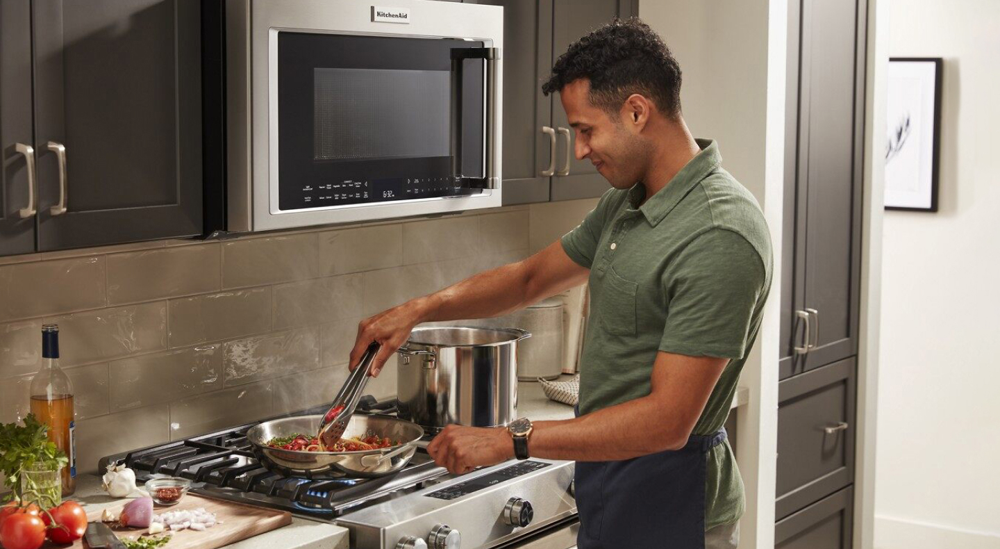Person cooking pasta on a range